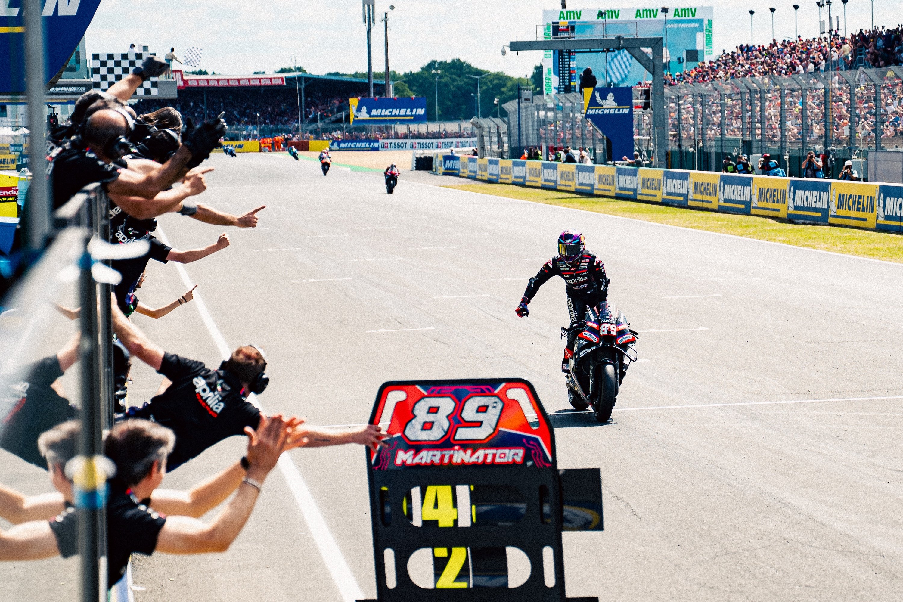 Jorge Martin Aprilia Racing in piedi sulla moto attraversa traguardo Sprint Le Mans 2026 cartello Martinator