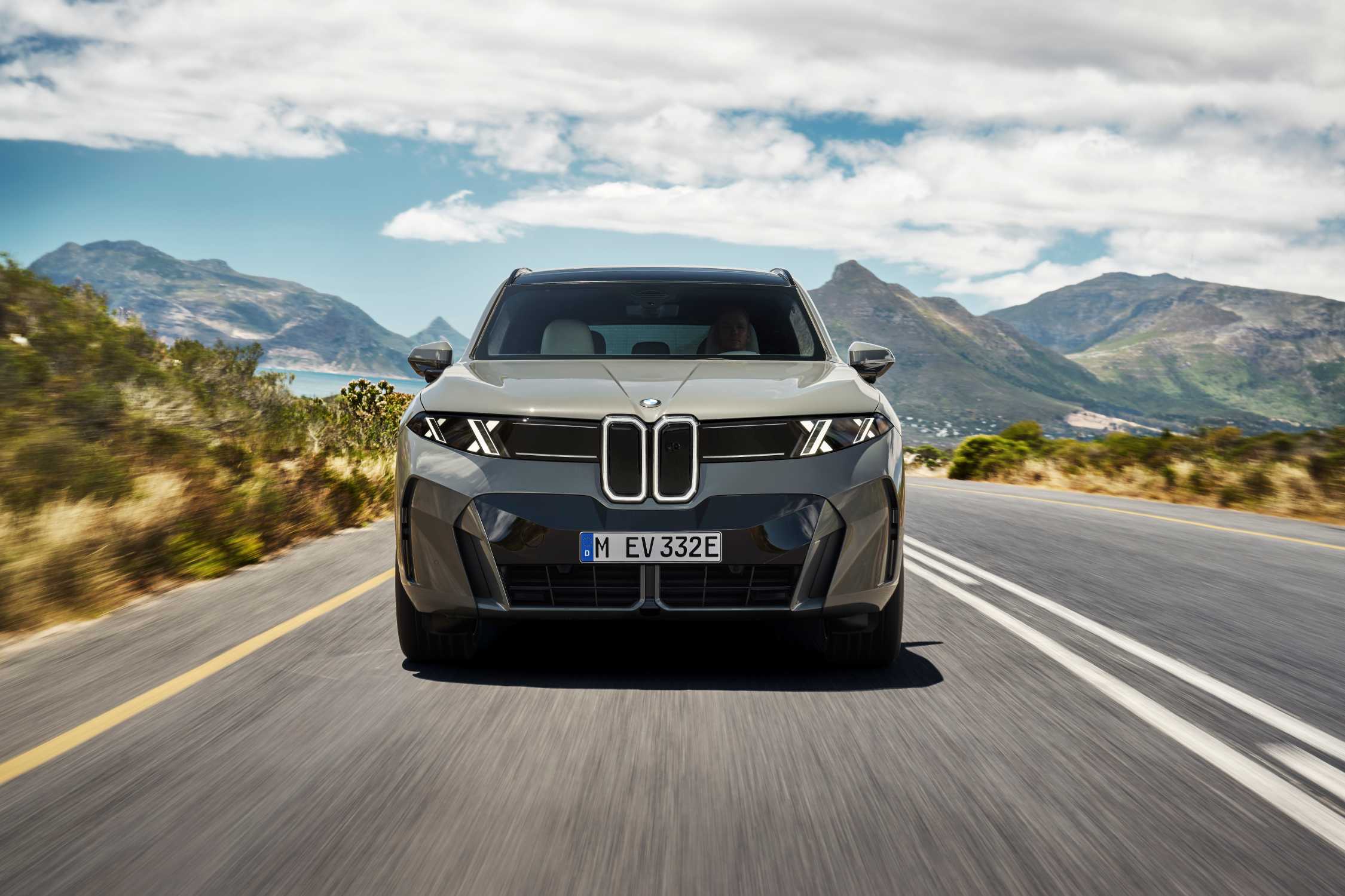 Nuova BMW iX5 2026 elettrica vista anteriore su strada di montagna