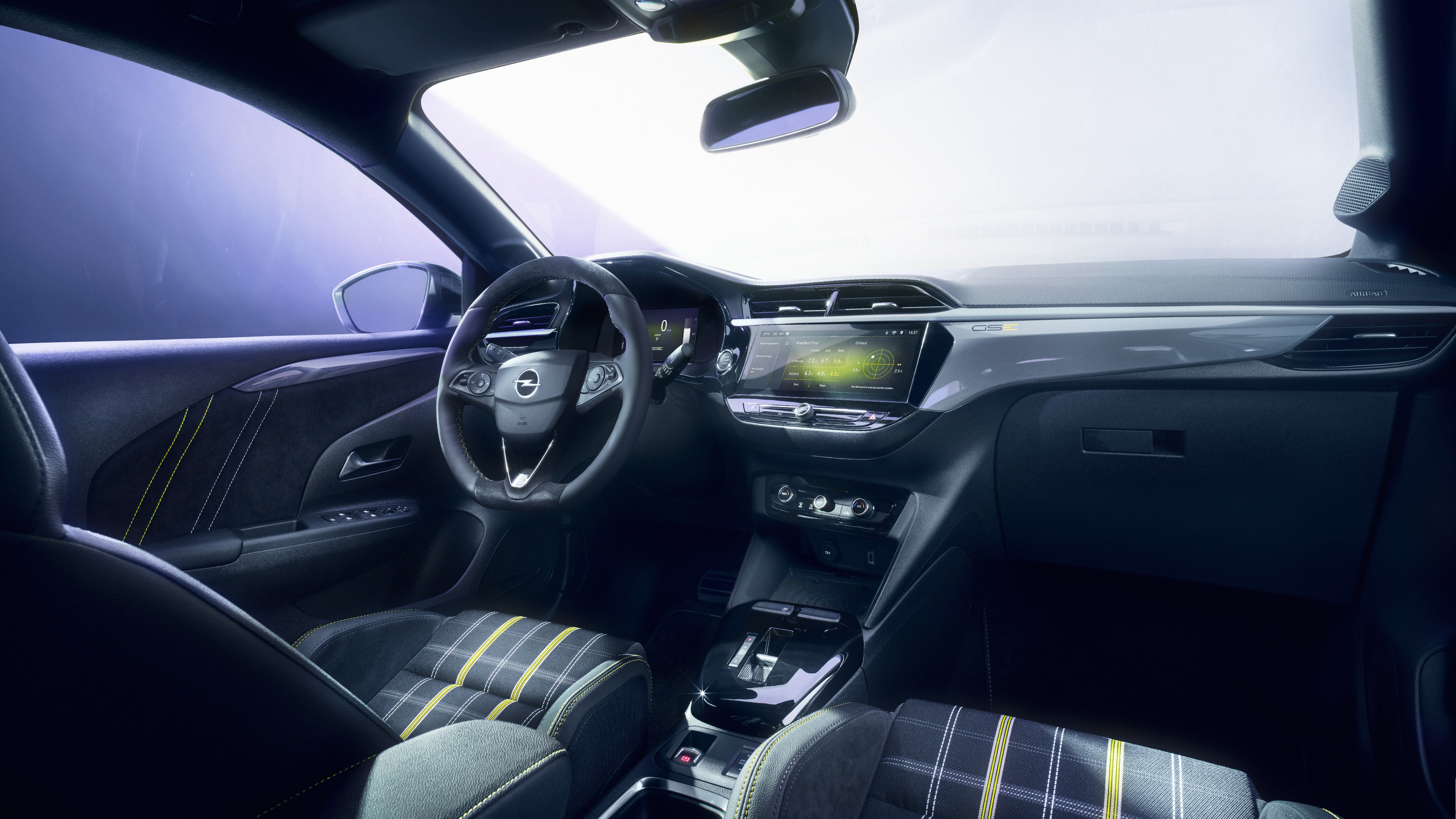 Opel Corsa GSE 2026 interni con sedili a scacchi gialli neri grigi e cinture gialle